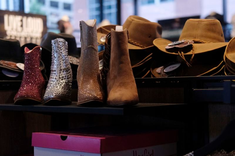 Cowboy hats and boots are displayed at the Ryman Auditorium gift shop in Nashville, Tenn., on July 30, 2024. (AP Photo/Luis Andres Henao)