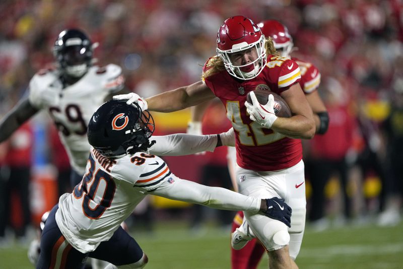 Kansas City Chiefs fullback Carson Steele, right, runs for a 31-yard gain as Chicago Bears defensive back Tarvarius Moore (30) defends during the first half of an NFL preseason football game Thursday, Aug. 22, 2024, in Kansas City, Mo. (AP Photo/Charlie Riedel)