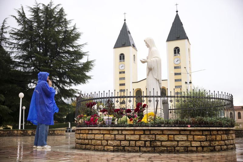 A pilgrim says their prayer next to the statue of the Virgin Mary in Medjugorje, Bosnia, Thursday, Sept. 19, 2024. (AP Photo/Armin Durgut)