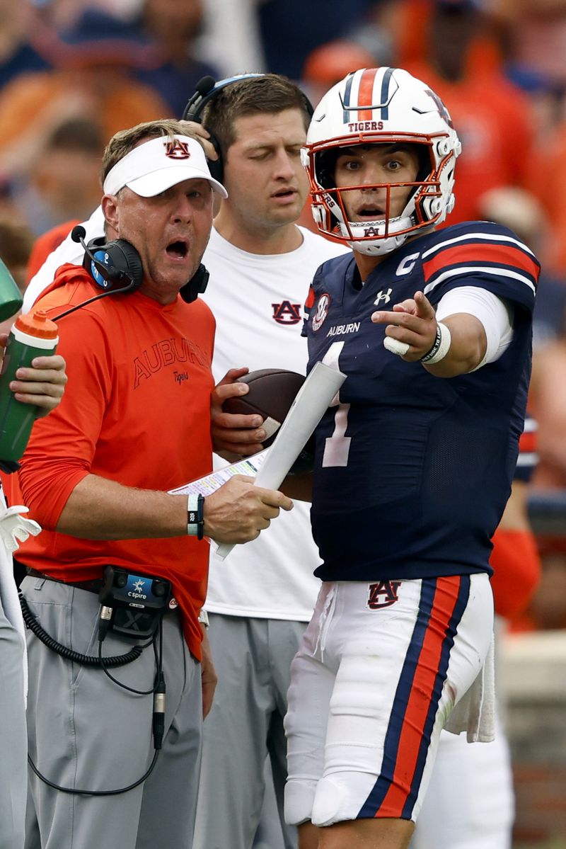 Auburn head coach Hugh Freeze talks with Auburn quarterback Payton Thorne (1) during a timeout in the second half of an NCAA college football game against Oklahoma, Saturday, Sept. 28, 2024, in Auburn, Ala. (AP Photo/Butch Dill)