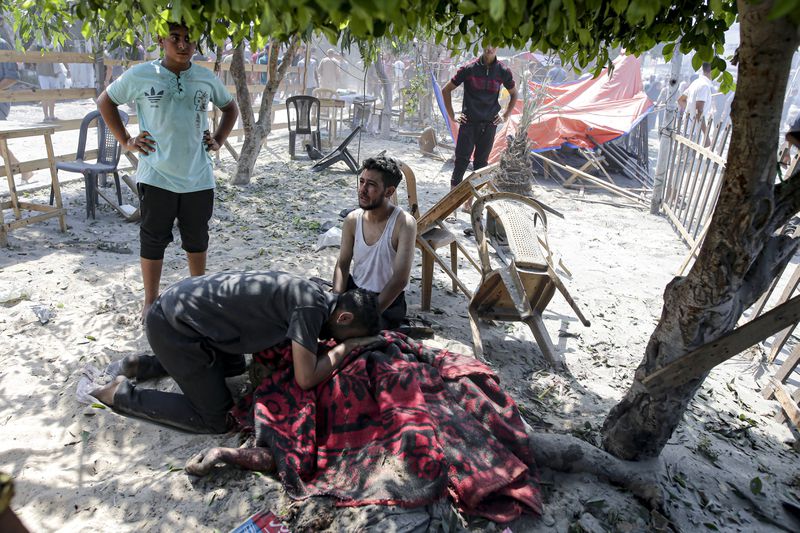 Palestinians mourn over the body of a relative killed in an Israeli bombardment on Khan Younis, southern Gaza Strip, Saturday, July 13, 2024. Israel said it targeted Hamas' shadowy military commander in a massive strike Saturday in the crowded southern Gaza Strip that killed at least 71 people, according to local health officials. Hamas immediately rejected the claim that Mohammed Deif was targeted. (AP Photo/Jehad Alshrafi)