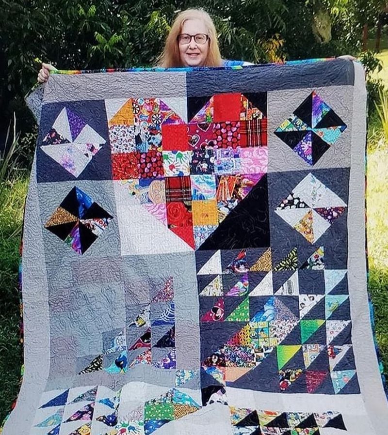 Melissa J. Walter Feuer is shown here with one of her quilt creations. She says she started quilting about 15 years ago. (Photo Courtesy of Melissa J. Walter Feuer)