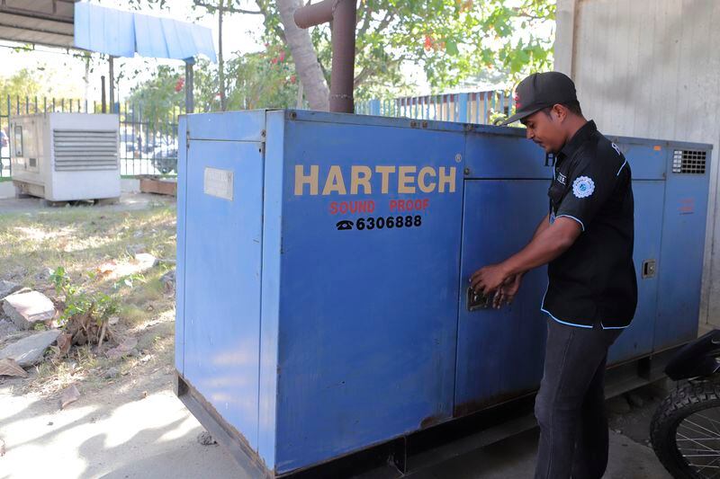 A man stands next to a generator at an office in Dili, East Timor, Friday, Sept. 6, 2024. (AP Photo/Firdia Lisnawati)