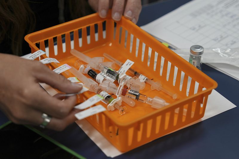 Vaccines are prepared for students during a pop-up immunization clinic at the Newcomer Academy in Louisville, Ky., on Thursday, Aug. 8, 2024. (AP Photo/Mary Conlon)