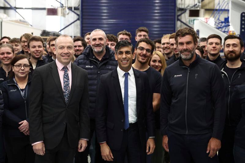 Britain's Prime Minister and Conservative Party leader Rishi Sunak, center, and Britain's Northern Ireland Secretary Chris Heaton-Harris, center left, pose with Artemis Technologies chief executive officer Iain Percy, center right, and staff during a visit to the maritime technology centre at a dockyard in Belfast, Friday May 24, 2024 as part of his campaign ahead of a general election on July 4. (Henry Nicholls/Pool Photo via AP)
