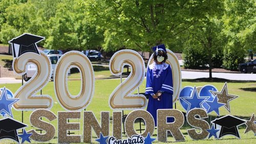 A McEachern High School graduate stands next to a sign congratulating seniors.