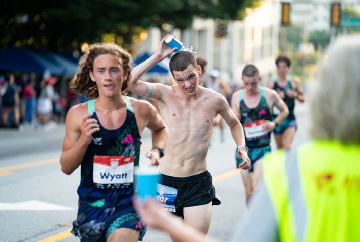 A runner dumps water on his head during the 55th running of The Atlanta Journal-Constitution Peachtree Road Race at "Cardiac Hill" on Peachtree Road NW in Atlanta on Thursday, July 4, 2024. (Seeger Gray / AJC)