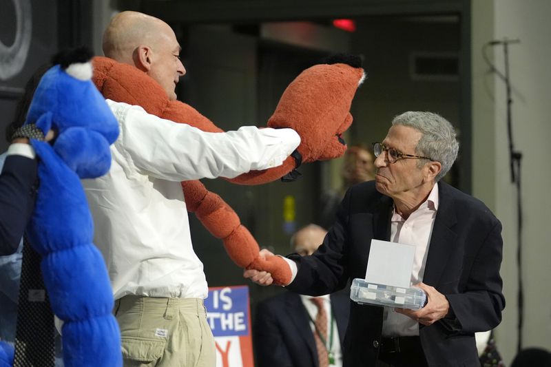 Eric Maskin, 2007 Nobel Laureate in Economics, right, presents an Ig Nobel award to a members of a team of researchers who who used chromatography to separate drunk and sober worms, during a performance at the Ig Nobel Prize ceremony at Massachusetts Institute of Technology, in Cambridge, Mass., Thursday, Sept. 12, 2024. (AP Photo/Steven Senne)