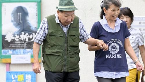 Iwao Hakamada, left, 88-year-old former boxer who has been on death row for nearly six decades after his murder conviction that his lawyers said was based on forced confession and fabricated evidence, is helped by a supporter as he goes for a walk in Hamamatsu, Shizuoka prefecture, central Japan Wednesday, Sept. 25, 2024. (Kyodo News via AP)