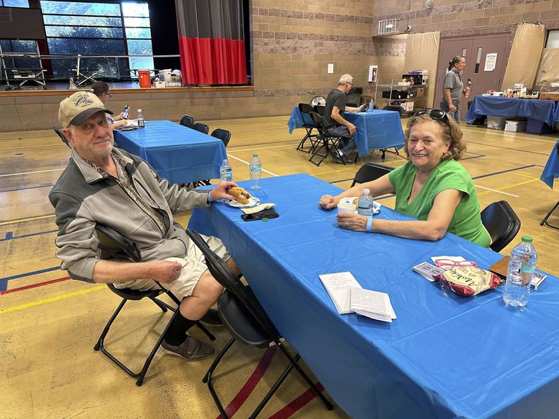 Rich Meyr, 82, left, and Evelyn Kelley, 77, sit at an evacuation center for those in the path of regional wildfires, Wednesday, Sept. 11, 2024, in Reno, Nevada. The two were the first — and so far only - arrivals at a new evacuation center set up Wednesday at a recreation center in south Reno where the Red Cross was prepared to handle 100 or more people if necessary. (AP Photo/Scott Sonner)