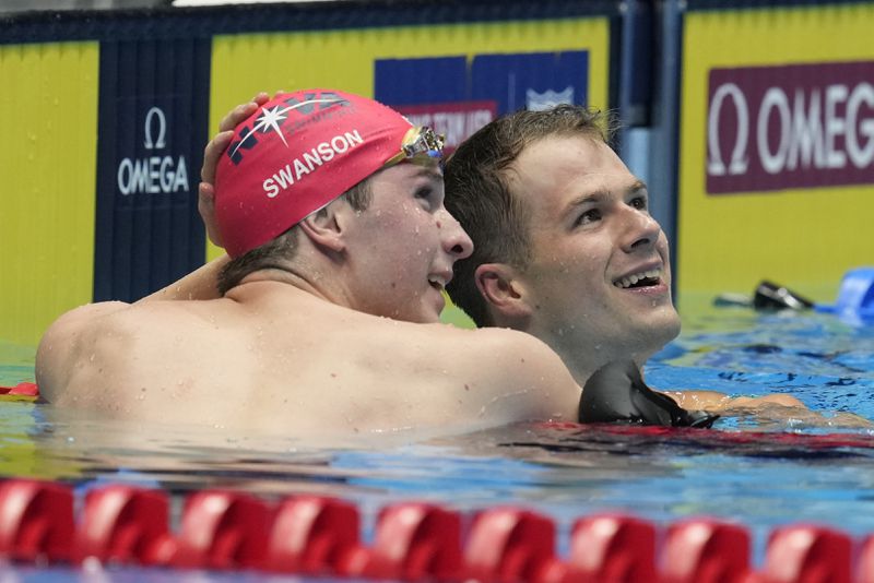 Nic Fink is congratulated by Charlie Swanson after winning the Men's 100 breaststroke finals Sunday, June 16, 2024, at the US Swimming Olympic Trials in Indianapolis. (AP Photo/Michael Conroy)