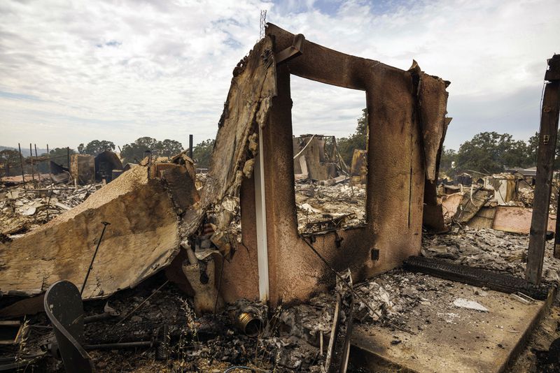 The remains of a structure destroyed by the Apache Fire as it burns in Palermo, Calif., on Tuesday, Jun. 25, 2024. According to Cal Fire, more than a dozen new fires sparked by lightning. (AP Photo/Ethan Swope)