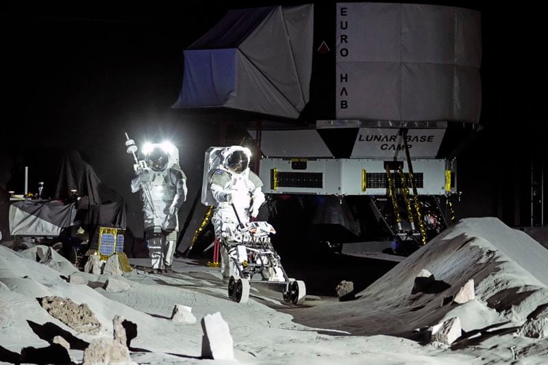 Astronauts Thomas Pesquet of France and Matthias Maurer of Germany demonstrate their training in lunar surface simulating conditions for future moon missions, like the Artemis lunar exploration program led by NASA, at the opening of the new LUNA facility at the European Astronaut Center in Cologne, Germany, Wednesday, Sept. 25, 2024. (AP Photo/Martin Meissner)