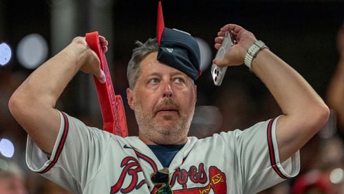 A fan rallies in the ninth inning of a make-up baseball game between the Cincinnati Reds and the Atlanta Braves, Monday, Sept. 9, 2024, in Atlanta. (AP Photo/Jason Allen)