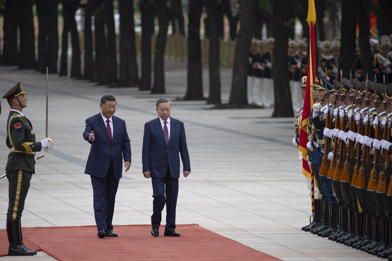 Chinese President Xi Jinping, center left, walks next to Vietnam's President To Lam as they pass by the honor guard during a welcome ceremony at the Great Hall of the People in Beijing Monday, Aug. 19, 2024. (Andres Martinez Casares/Pool Photo via AP)