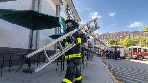 Atlanta firefighter J. Owens of 10-truck prepares to enter the Ponce De Leon Avenue Whole Foods after fire brok eout in a pizza oven. About 70 employees and 30 patronswere evacuated with no injuries. The fire had already been extinguished when fire crews arrived. (John Spink/AJC)