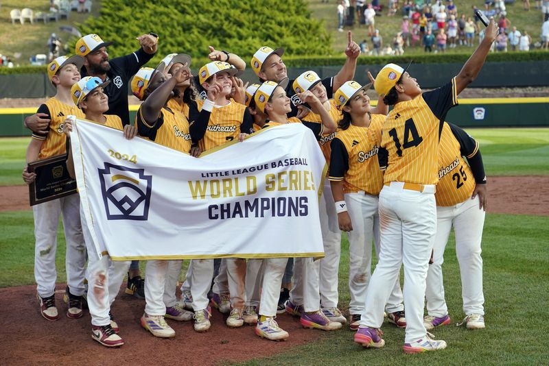 Lake Mary, Fla.'s James Feliciano (14) takes a selfie of the team after their win against Taiwan during the Little League World Series Championship game in South Williamsport, Pa., Sunday, Aug. 25, 2024. (AP Photo/Tom E. Puskar)