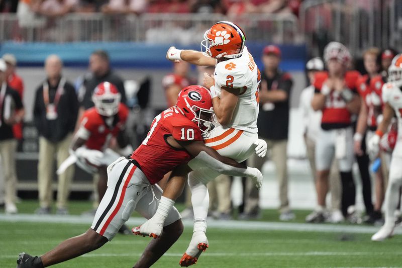 Clemson quarterback Cade Klubnik (2) is hit by Georgia linebacker Damon Wilson II (10) after releasing a pass during the second half of an NCAA college football game Aug. 31, 2024, in Atlanta. (AP Photo/John Bazemore)