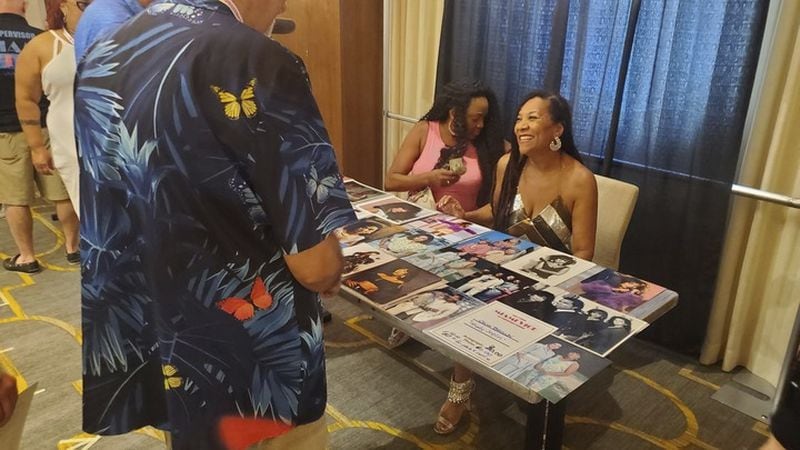 Fans gathered at the Royal Palm South Beach in Miami Beach, Fla., on Friday, Sept. 13, 2024, to celebrate the 40th anniversary of the television series "Miami Vice." Actress Olivia Brown, right, who played Detective Trudy Joplin, speaks with a fan. (AP Photo/David Fischer)