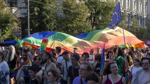 People carry a rainbow flag as they attend a pride march in Belgrade, Serbia, Saturday, Sept. 7, 2024. (AP Photo/Marko Drobnjakovic)