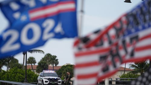 Police patrol on a bridge beside the Mar-a-Lago estate of Republican presidential nominee and former President Donald Trump, as a supporter flies flags to express support for Trump one day after an apparent assassination attempt, in Palm Beach, Fla., Monday, Sept. 16, 2024. (AP Photo/Rebecca Blackwell)