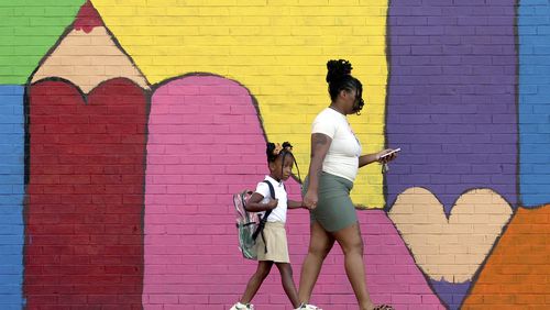 Bria Gibbs brings her daughter Tai'la Harris, 4, into Columbia Elementary school for the first day of classes for St. Louis Public Schools on Monday, Aug. 19, 2024. Gibbs drove her daughter to school. (David Carson/St. Louis Post-Dispatch via AP)