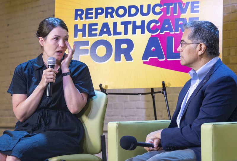 U.S. Health Secretary Xavier Becerra, right, listens as Jillaine St. Michel, a patient who was forced to travel to Seattle to access an abortion speaks during a conversation with local patients and providers who have been impacted by Idaho's abortion restrictions held at the Linen Building in Boise, Idaho, Wednesday, June 26, 2024. (AP Photo/Kyle Green)