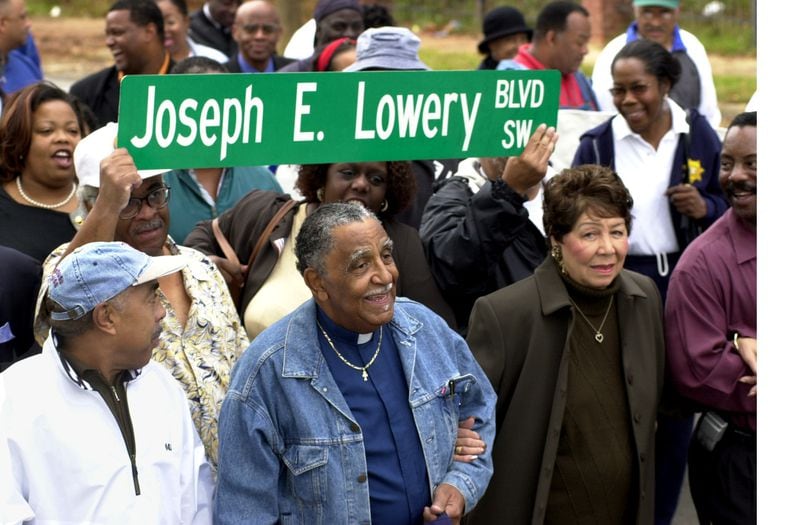 Rev. Joseph Lowery walks arm-in-arm with his wife Evelyn down Ashby Street between Ralph David Abernathy Boulevard and Martin Luther King, Jr. Drive in Southwest Atlanta in 2001. Ashby Street was being changed to Joseph E. Lowery Boulevard. (CHARLOTTE B. TEAGLE/AJC staff)