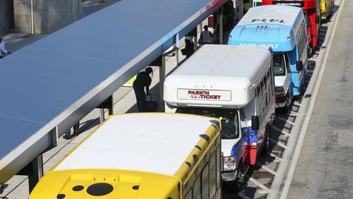 Shuttle vans parked at Hartsfield-Jackson International Airport. JOHN SPINK/JSPINK@AJC.COM