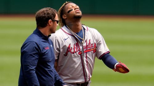 Atlanta Braves' Ronald Acuña Jr., right, walks off the field with a trainer after being injured while running the bases during the first inning of a baseball game against the Pittsburgh Pirates in Pittsburgh, Sunday, May 26, 2024. (AP Photo/Gene J. Puskar)