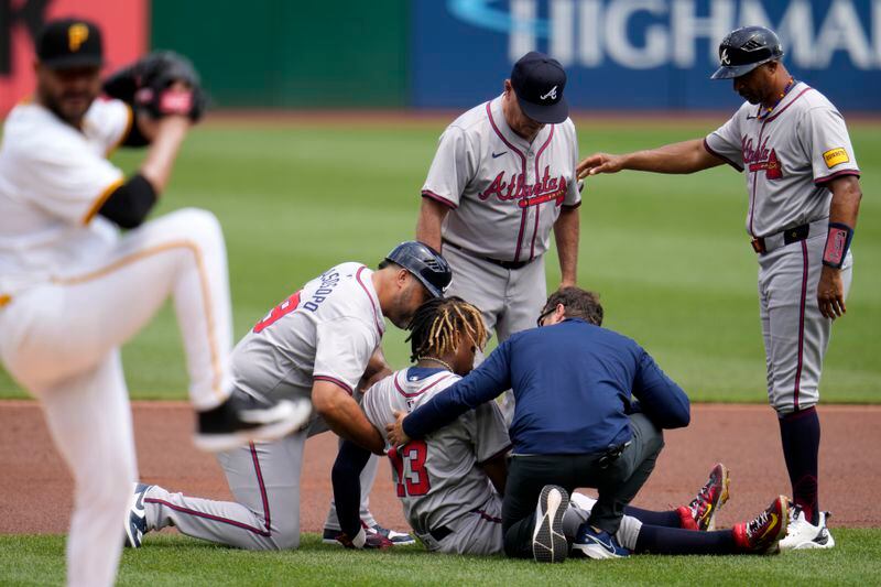 Atlanta Braves' Ronald Acuña Jr. is tended to after being injured while running the bases during the first inning of a baseball game against the Pittsburgh Pirates in Pittsburgh, Sunday, May 26, 2024. (AP Photo/Gene J. Puskar)