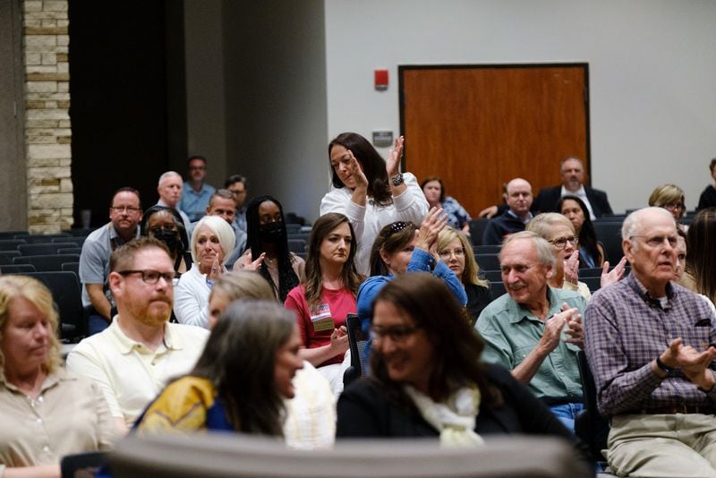 Audience members at a Cherokee County school board meeting cheer for a speaker who advocates for removing books some deem objectionable. Members of the public voiced their opinions at the school board meeting in Canton on Thursday, April 21, 2022.   (Arvin Temkar / arvin.temkar@ajc.com)