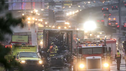 DeKalb County Firefighters emerge from the cab of a burned out truck Thursday morning, Nov. 5, 2015 after putting out a fire that erupted during the early morning commute.