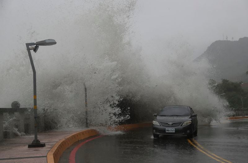 A car moves along the shore in Kaohsiung, Southern Taiwan, Wednesday, Oct. 2, 2024, as Typhoon Krathon is expected to hit the area. (AP Photo/Chiang Ying-ying)