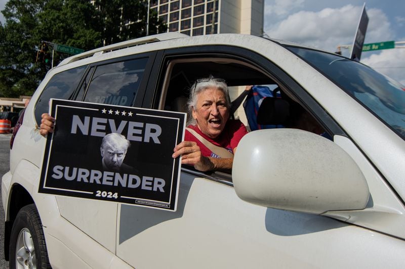 A supporter of former President Donald Trump holds a sign outside a rally for Vice President Kamala Harris in Atlanta on Tuesday.