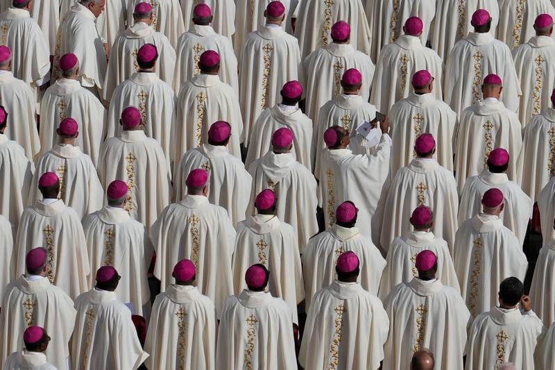 A bishop uses a smartphone as Pope Francis presides over a mass in St. Peter's Square, at the Vatican, for the opening of the second session of the 16th General Assembly of the Synod of Bishops, Wednesday, Oct. 2, 2024. (AP Photo/Gregorio Borgia)