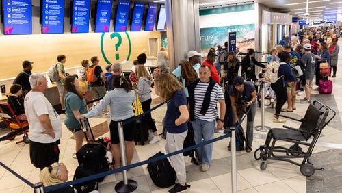 Travelers line up at a Delta Air Lines desk at Hartsfield-Jackson Atlanta International Airport domestic terminal late in the evening on July 20, following a global technology outage that hampered airlines and other industries. (Arvin Temkar/The Atlanta Journal-Constitution)