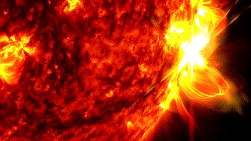 This image provided by NASA's Solar Dynamics Observatory shows a solar flare, right, on May 14, 2024, captured in the extreme ultraviolet light portion of the spectrum colorized in red and yellow. An international team of mathematicians and scientists reported Wednesday, May 22, 2024, that the sun's magnetic field originates much closer to the surface than previously thought. (NASA/SDO via AP)