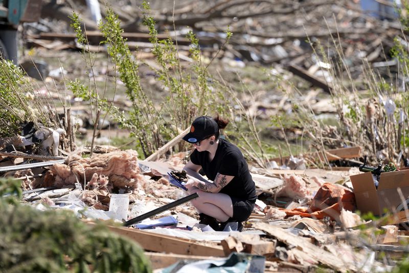 Jena Wiggins looks to recover items from her husband's grandparents' tornado-damaged home, Thursday, May 23, 2024, in Greenfield, Iowa. (AP Photo/Charlie Neibergall)