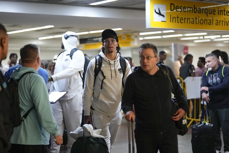 Green Bay Packers' Christian Watson, center, arrives at Sao Paulo International airport ahead of a game against the Philadelphia Eagles, in Guarulhos, great Sao Paulo area, Wednesday, Sept. 4, 2024. (AP Photo/Andre Penner)