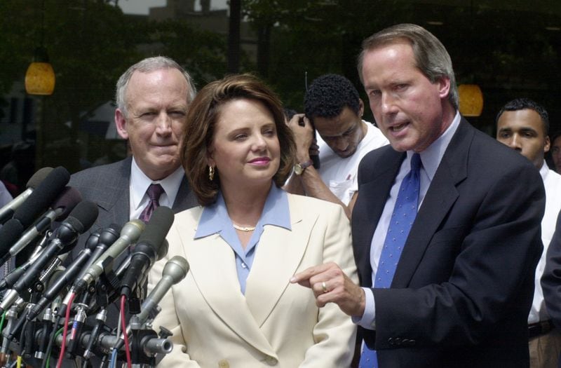 John Ramsey, left, and his wife Patsy Ramsey listened as their attorney Lin Wood, right, answered a question during a sidewalk press conference in downtown Atlanta after spending the morning being interviewed by Boulder, Colo., law enforcement and prosecution. (AJC file photo)