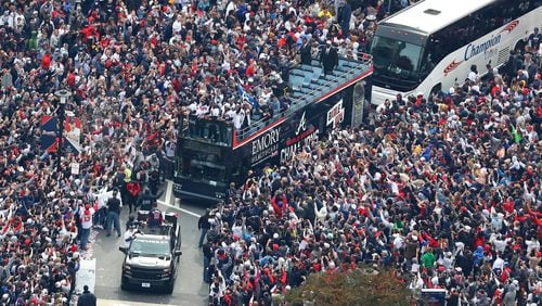 110521 ATLANTA: Braves players hoist the Commissioner's Trophy from the top of a double decker bus surrounded by thousands of fans as they arrive in the Battery outside Truist Park while the Atlanta Braves host a World Series Championship Parade and celebration on Friday, Nov. 5, 2021, in Atlanta.   “Curtis Compton / Curtis.Compton@ajc.com”