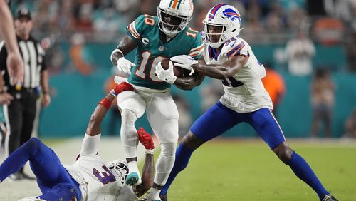 Buffalo Bills cornerback Rasul Douglas (31) and safety Damar Hamlin (3) stop Miami Dolphins wide receiver Tyreek Hill (10) during the first half of an NFL football game, Thursday, Sept. 12, 2024, in Miami Gardens, Fla. (AP Photo/Rebecca Blackwell)