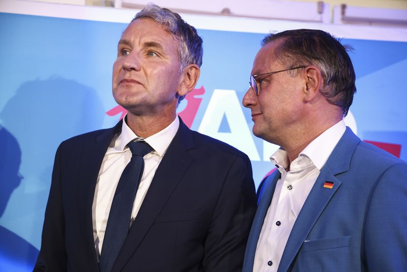 Right-wing Alternative for Germany (AfD) party co-leader Tino Chrupalla, right, and Thuringia AfD party leader Bjoern Hoecke, left, react after first exit polls of the Brandenburg state election in Potsdam, Germany, Sunday, Sept. 22, 2024. (Liesa Johannssen/Pool Photo via AP)