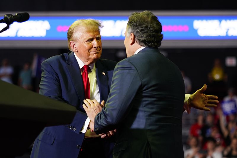 Republican presidential candidate former President Donald Trump, left, greets Republican Senate candidate Dave McCormick at a campaign rally, Saturday, June 22, 2024, at Temple University in Philadelphia. (AP Photo/Chris Szagola)