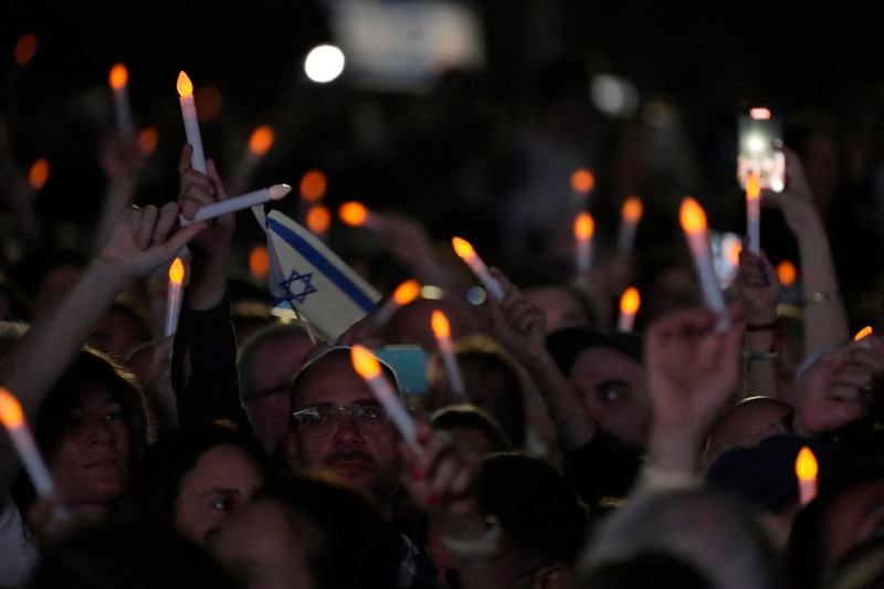 Members of the Jewish community wave electronic candles as they gather at a park in Sydney, Australia, on Monday, Oct. 7, 2024, as mourners marked the anniversary of the Oct. 7, 2023, attack. (AP Photo/Rick Rycroft)