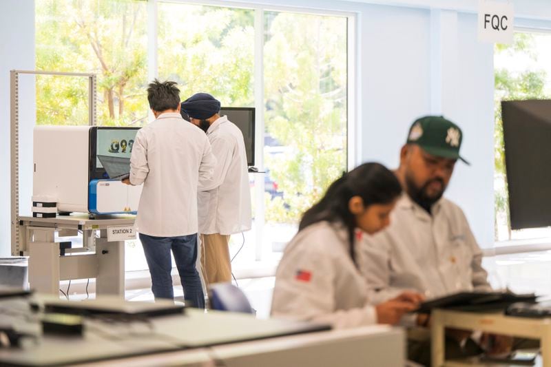 Technicians work inside the sequence instrument manufacturing department at Complete Genomics in San Jose, Calif., Monday, July 22, 2024. (AP Photo/Nic Coury)