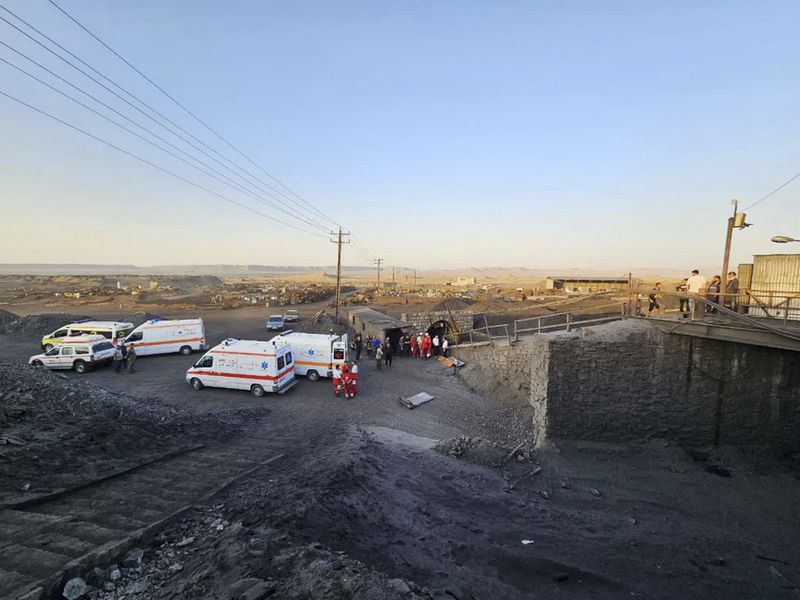 In this photo released by Iranian Red Crescent Society, ambulances stand at the site of a coal mine where methane leak sparked an explosion on Saturday, in Tabas, some 335 miles (540 kilometers) southeast of the capital Tehran, Iran, Sunday, Sept. 22, 2024. (Iranian Red Crescent Society, via AP)