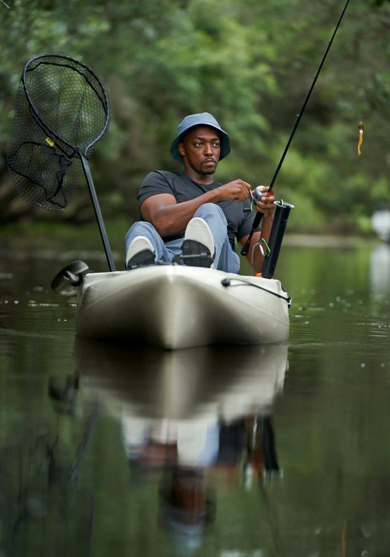 This image released by National Geographic shows actor/host Anthony Mackie Anthony fishing from his kayak on the Bayous of Violet, La., during the filming of "Shark Beach with Anthony Mackie." (Brian Roedel/National Geographic via AP)