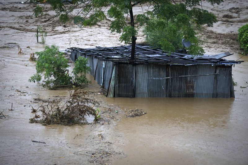 A tin shed lies partially submerged at the edge of the Bagmati River in spate after heavy rains in Kathmandu, Nepal, Saturday, Sept. 28, 2024. (AP Photo/Gopen Rai)